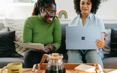 Dos mujeres consultan una computadora portátil en casa para buscar información