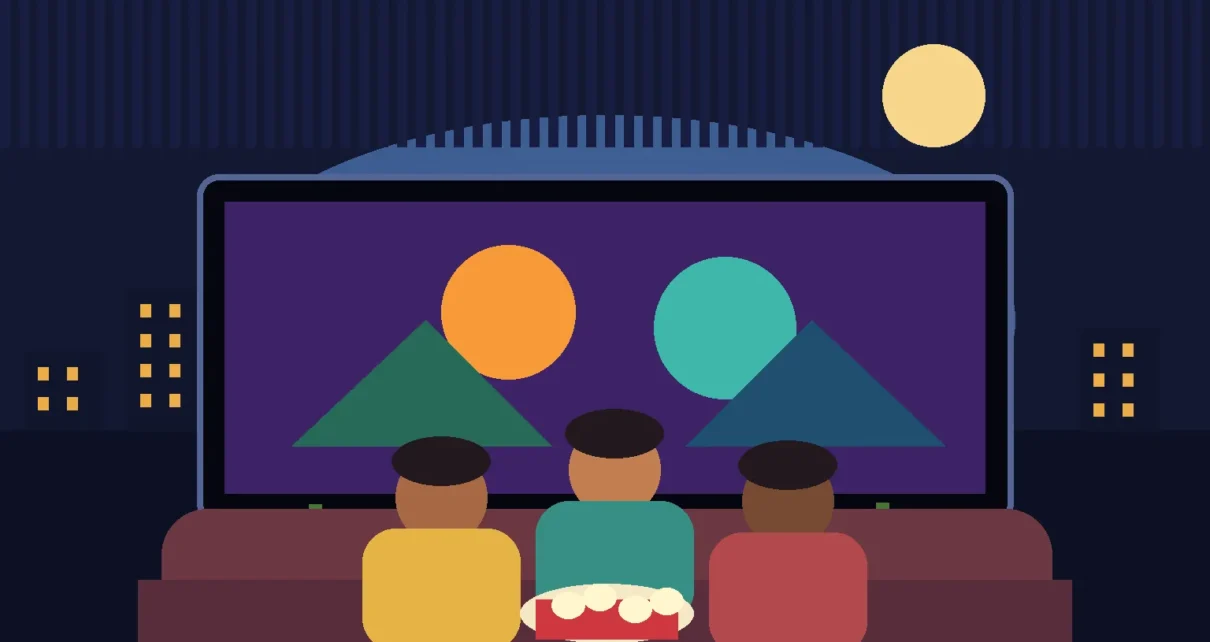 Familia latina observa una pantalla con animación y decoraciones de Halloween
